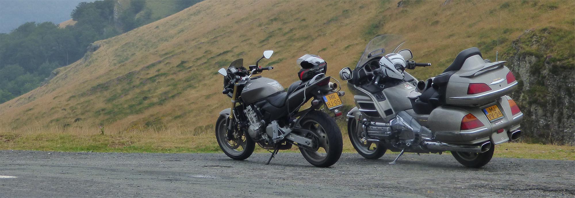 Een Honda Goldwing GL1800 met Nederlands kenteken en een Honda naked bike langs een bergweg