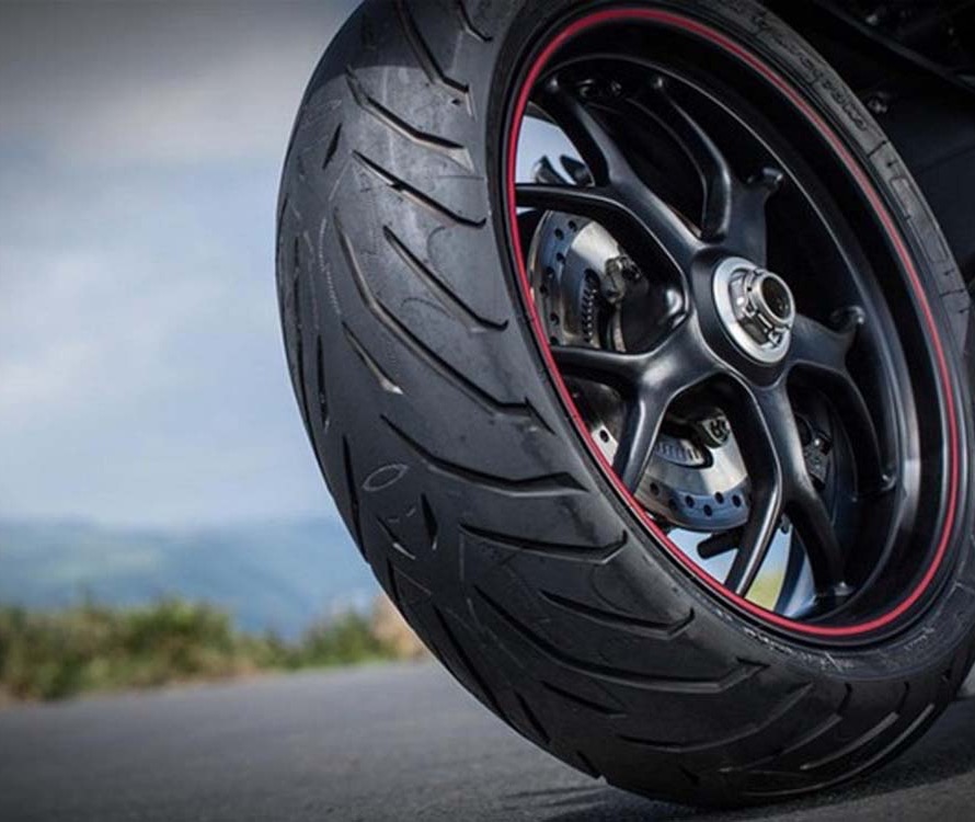 Achterband van een motor op een zwarte velg met rode velgrand, close-up