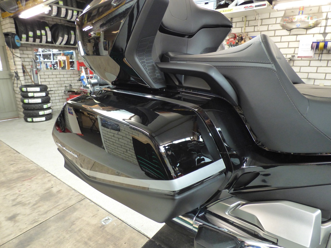 Zijkoffer van een Honda Goldwing GL1800 in de werkplaats, met een rek motorbanden op de achtergrond